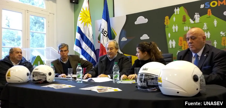 Mayo Amarillo en Montevideo 42 Autoridades de UNASEV y del Municipio CH en una mesa con cascos de moto, en la presentación de un proyecto de educación vial.