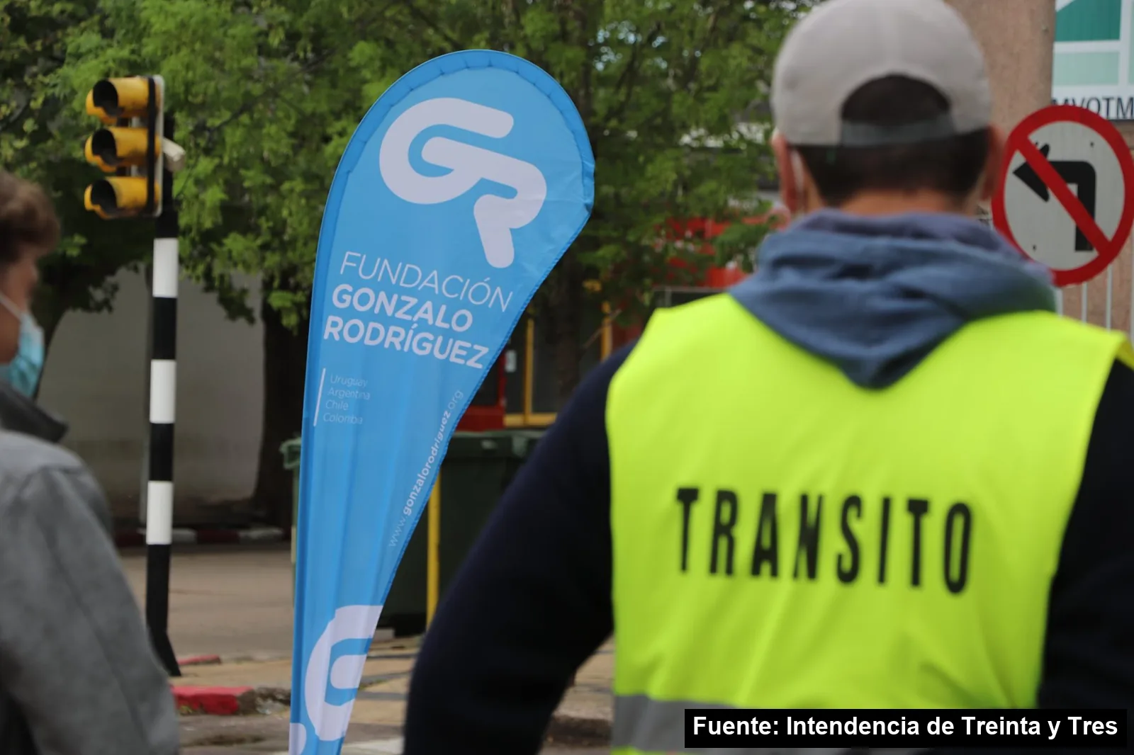 Mayo Amarillo en Treinta y Tres (ciudad) 4 Inspector de Tránsito de espaldas junto a una bandera de la Fundación Gonzalo Rodríguez en el punto de chequeo de sillas infantiles de Treinta y Tres