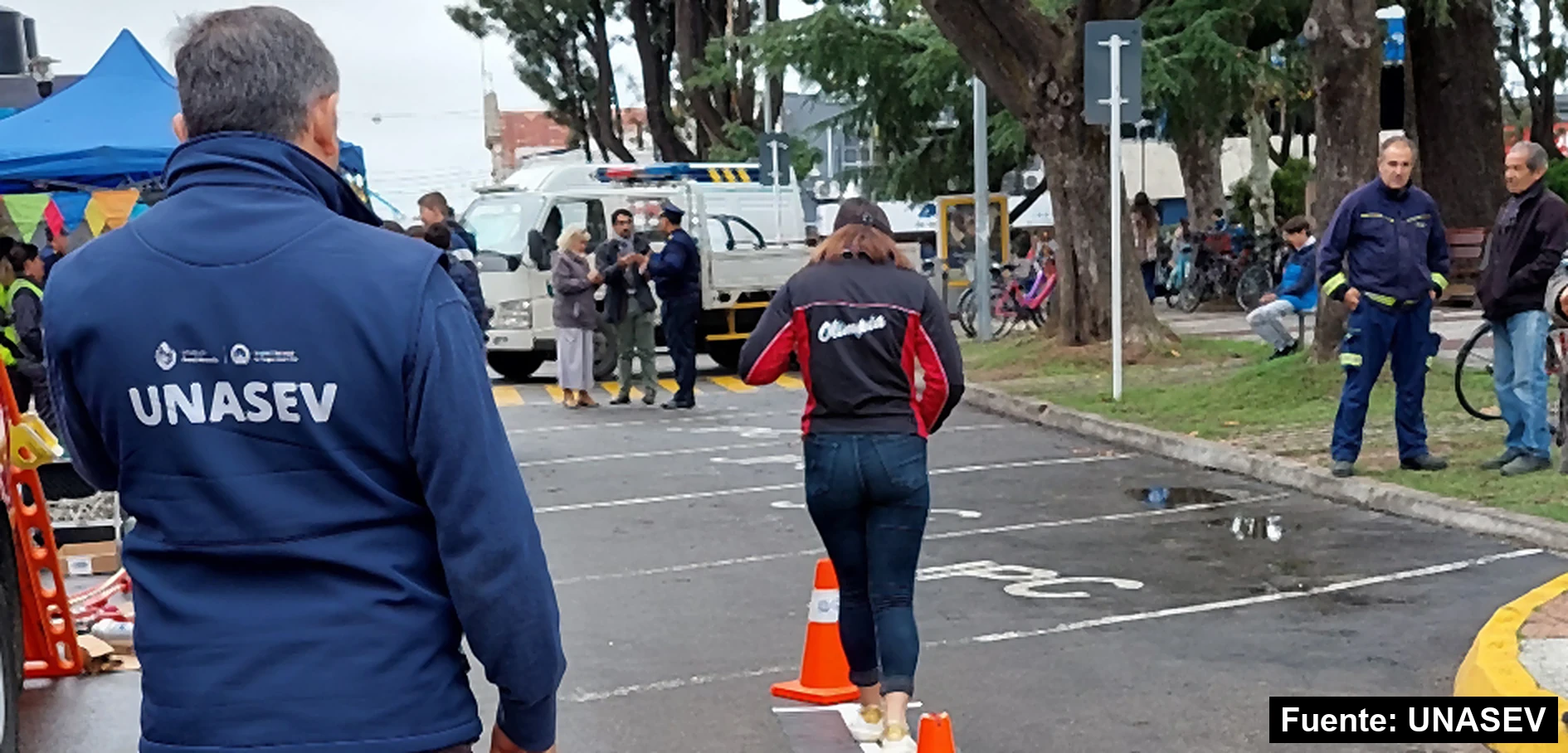 Integrante de UNASEV de espaldas mira a una joven recorrer un circuito de conos en Canelones