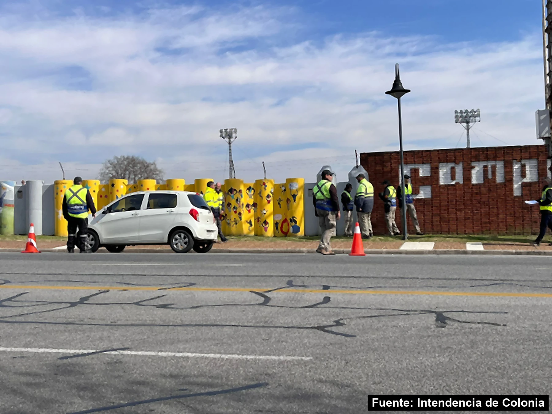 Mayo Amarillo en Colonia del Sacramento 3 Inspectores de tránsito con chalecos reflectivos hacen la práctica del curso de actualización junto a un auto y conos