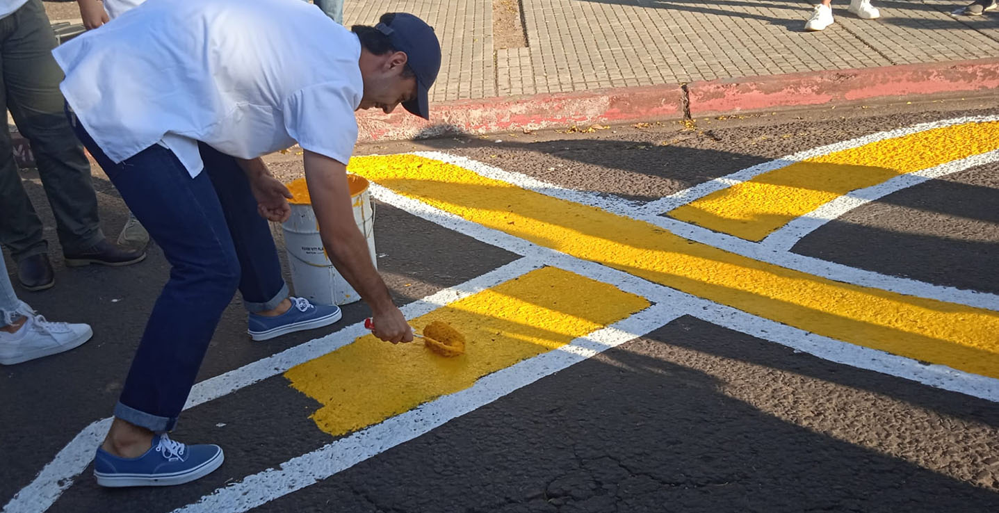 Un participante pinta el lazo amarillo frente a la Regional Norte en 2023