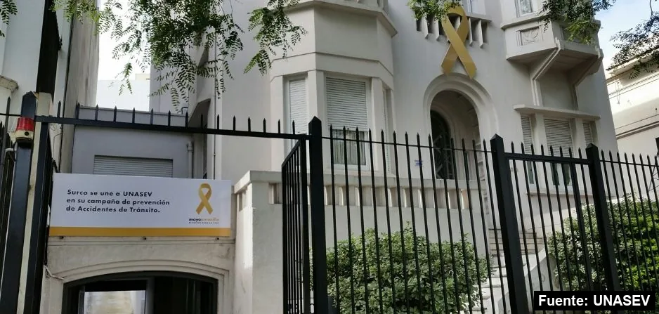 La fachada de SURCO Seguros en Bulevar Artigas, con un gran lazo amarillo y un cartel de adhesión a Mayo Amarillo.