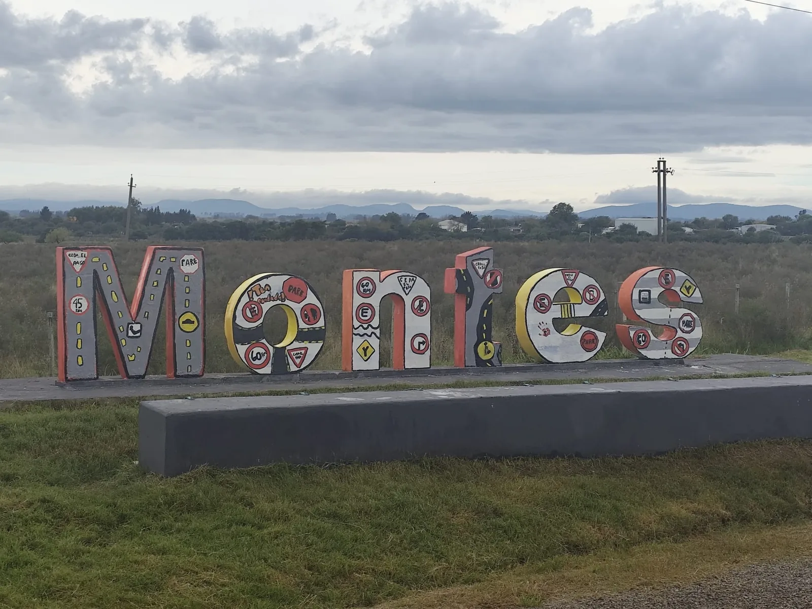 Mayo Amarillo en Montes 1 Letras con el nombre de Montes pintadas con señales de tránsito por estudiantes del liceo, con las sierras al fondo