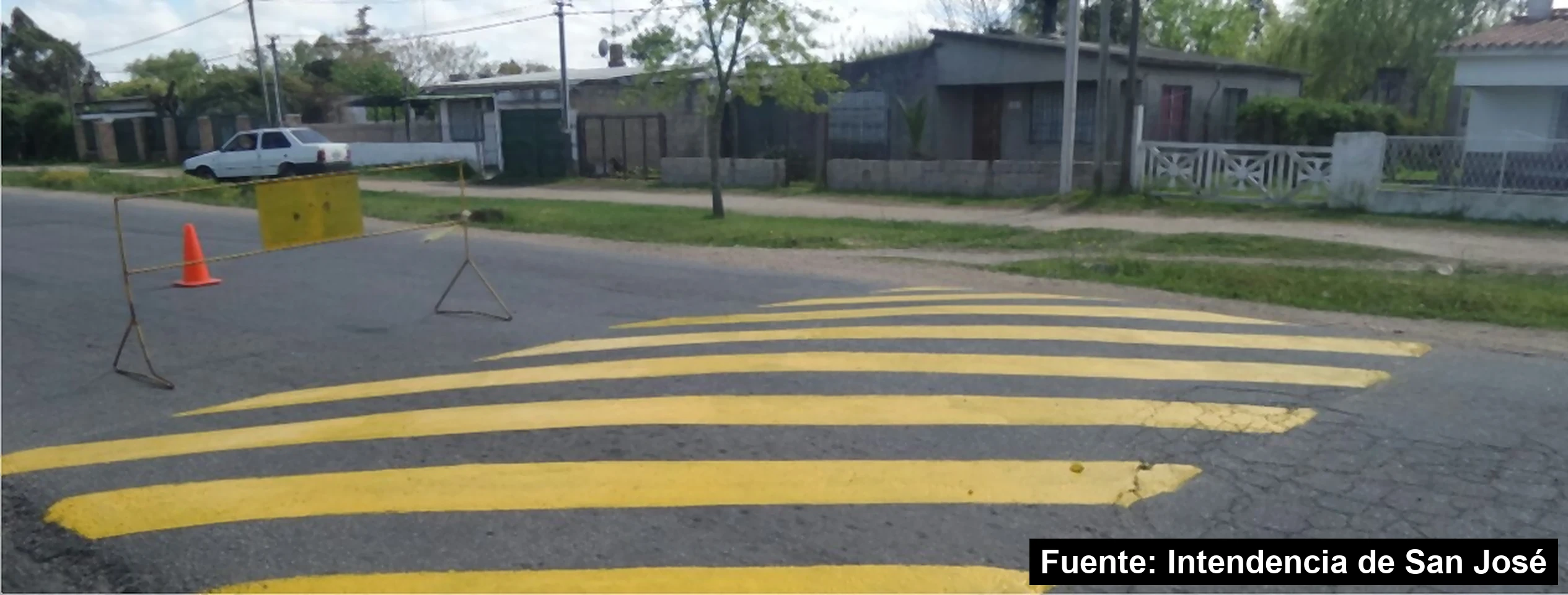 Lomada recién pintada de amarillo en una calle de Delta El Tigre, Ciudad del Plata, con un cono y una valla