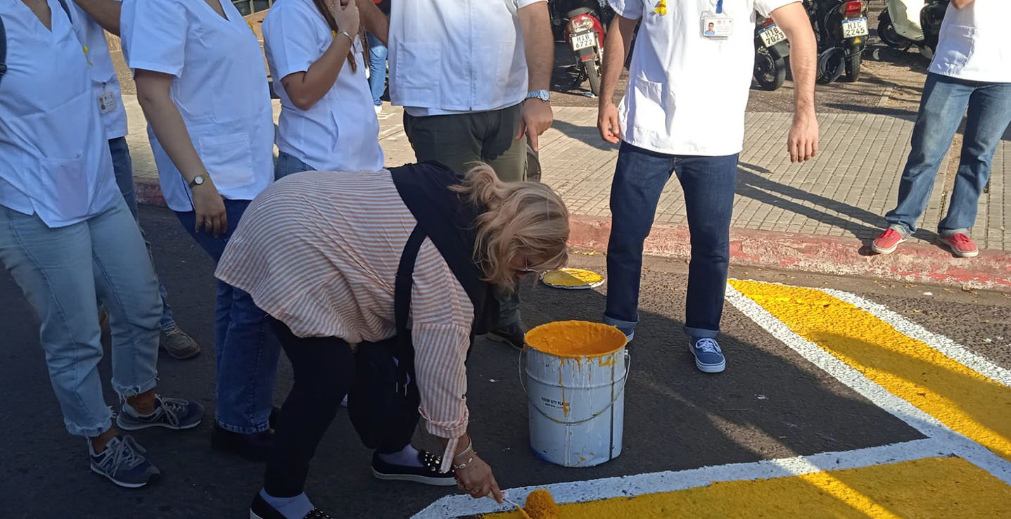 Participante pinta el lazo amarillo en la Regional Norte, Salto, 2023
