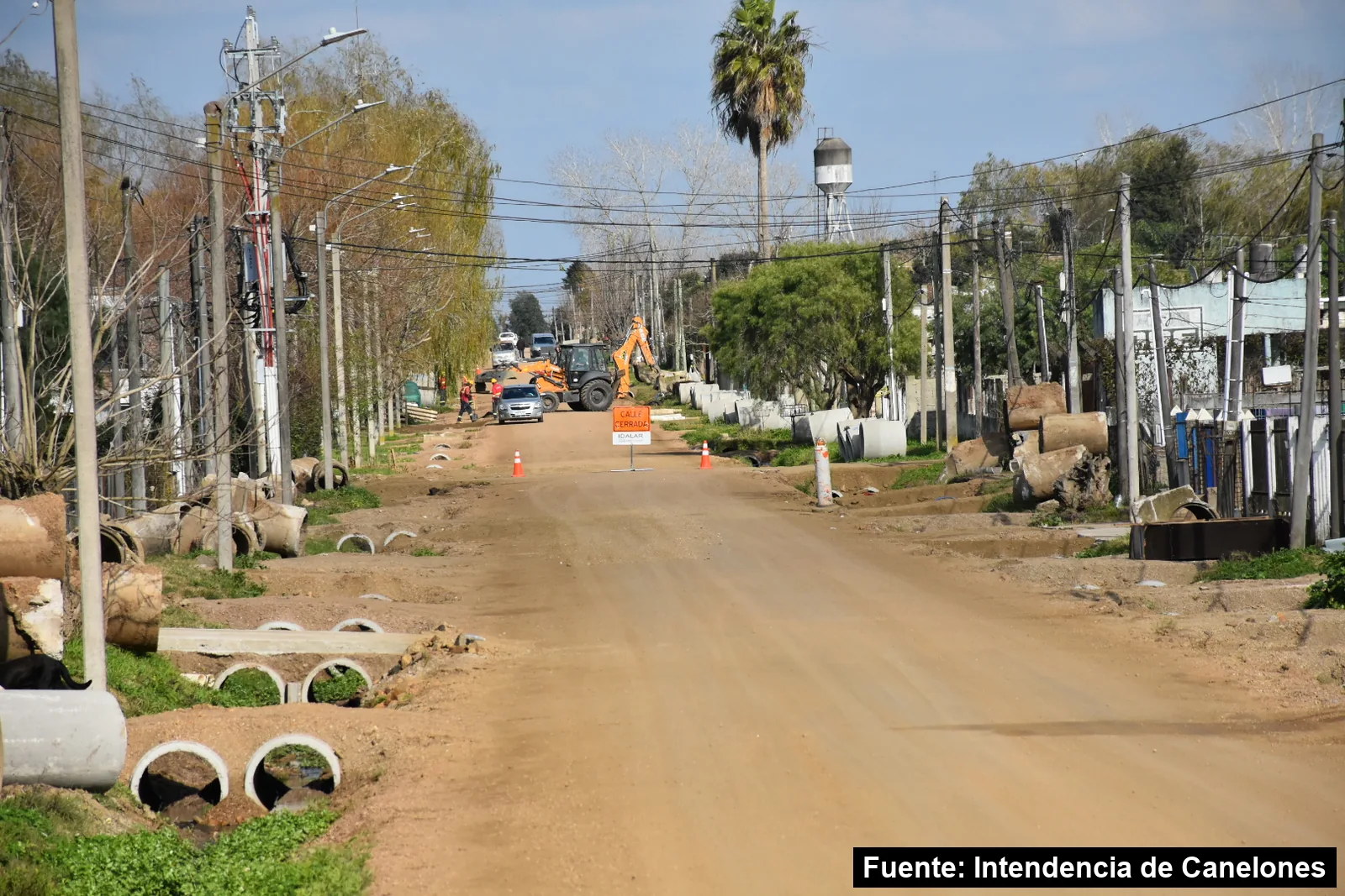 Mayo Amarillo en Barros Blancos 2 Calle de tierra con caños de drenaje a los costados y máquinas trabajando en Villa Castellana, Barros Blancos