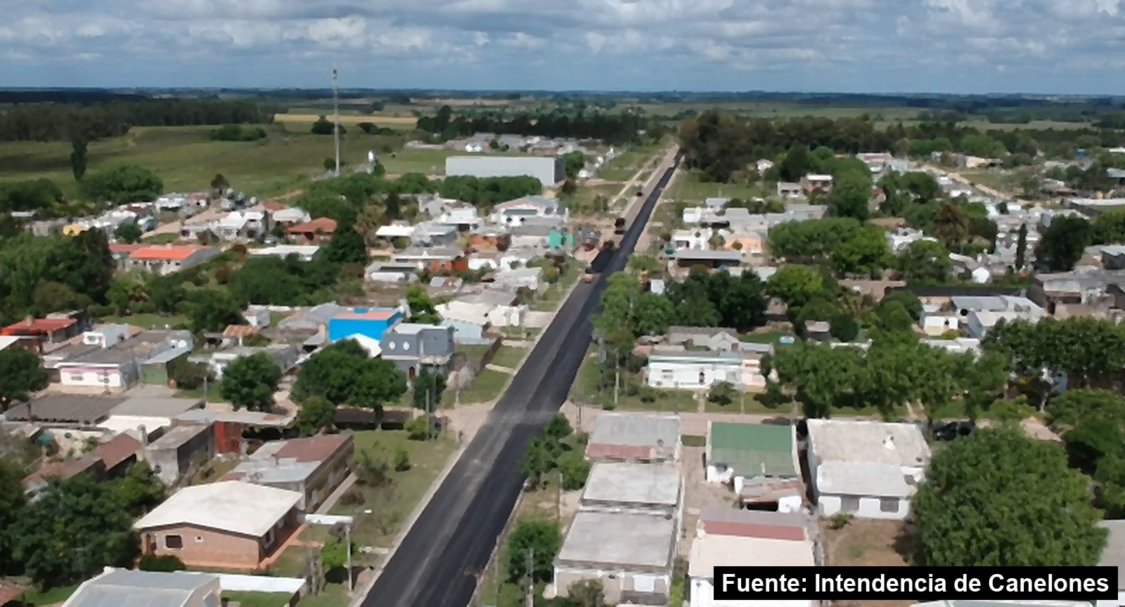 Mayo Amarillo en San Bautista 6 Vista aérea de San Bautista, Canelones, con una calle recién pavimentada entre las casas y el campo al fondo