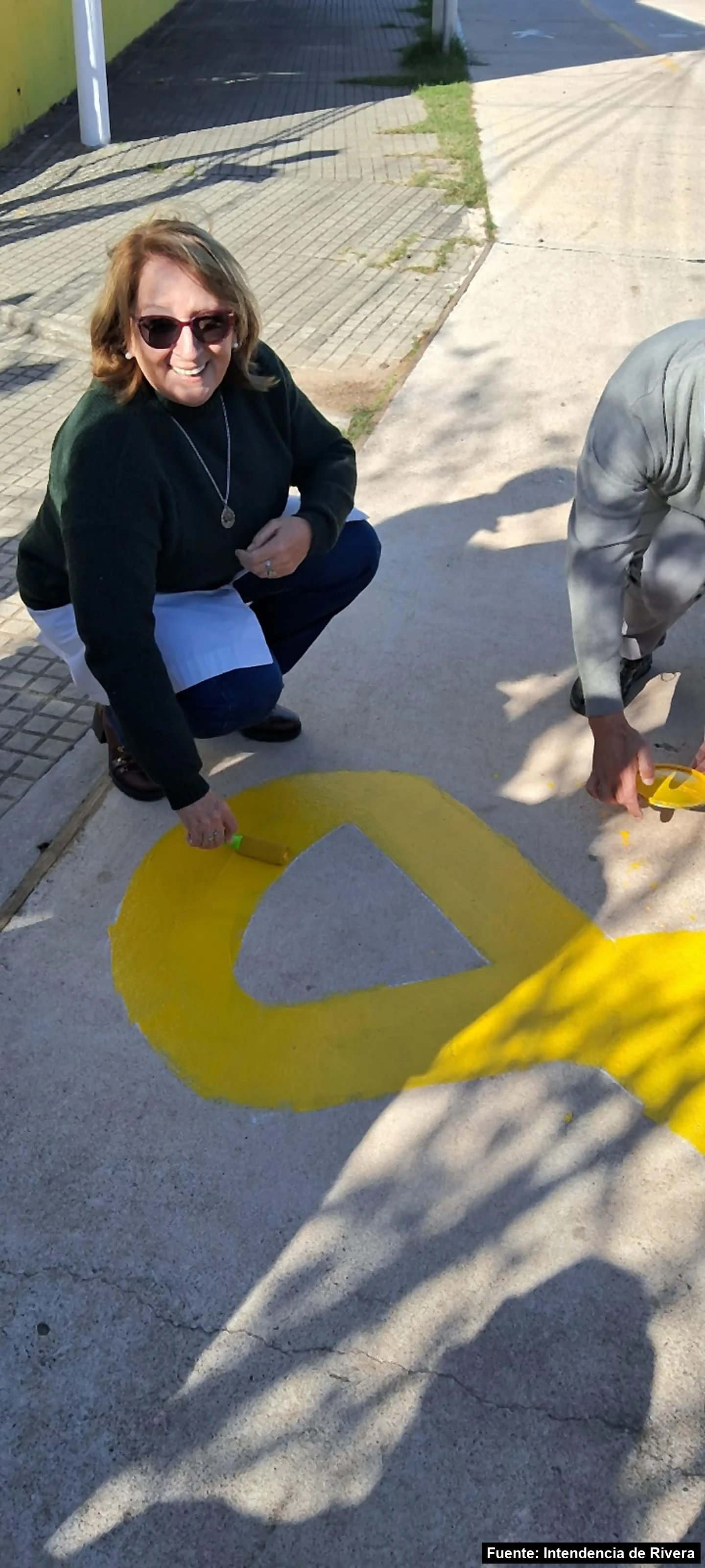 Mayo Amarillo en Tranqueras 3 Una docente pinta de amarillo el contorno de un lazo en la vereda de una escuela de Tranqueras