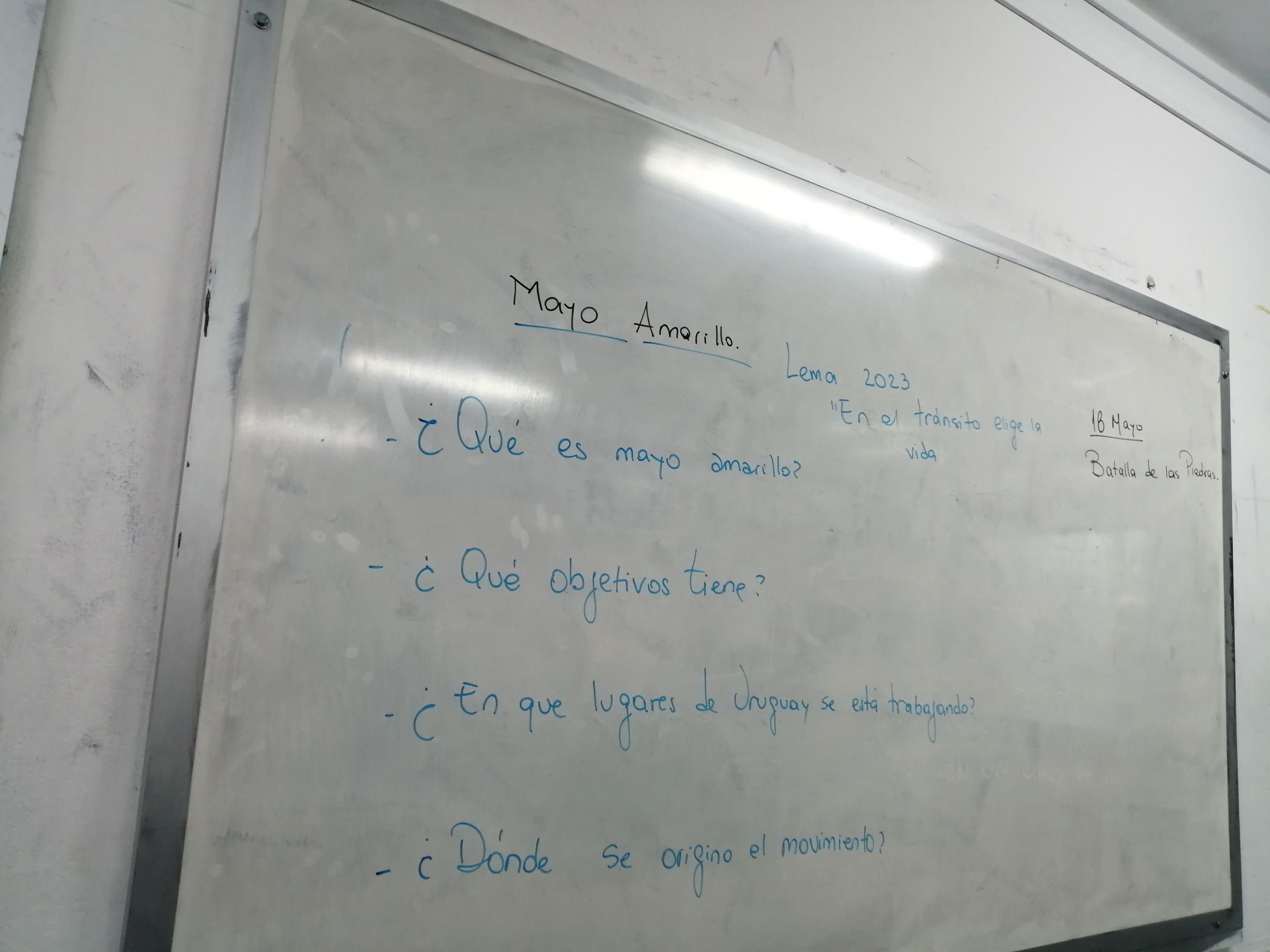 Mayo Amarillo en Sarandí Grande 8 Pizarrón de un aula con el título Mayo Amarillo, el lema 2023 y cuatro preguntas escritas con marcador azul