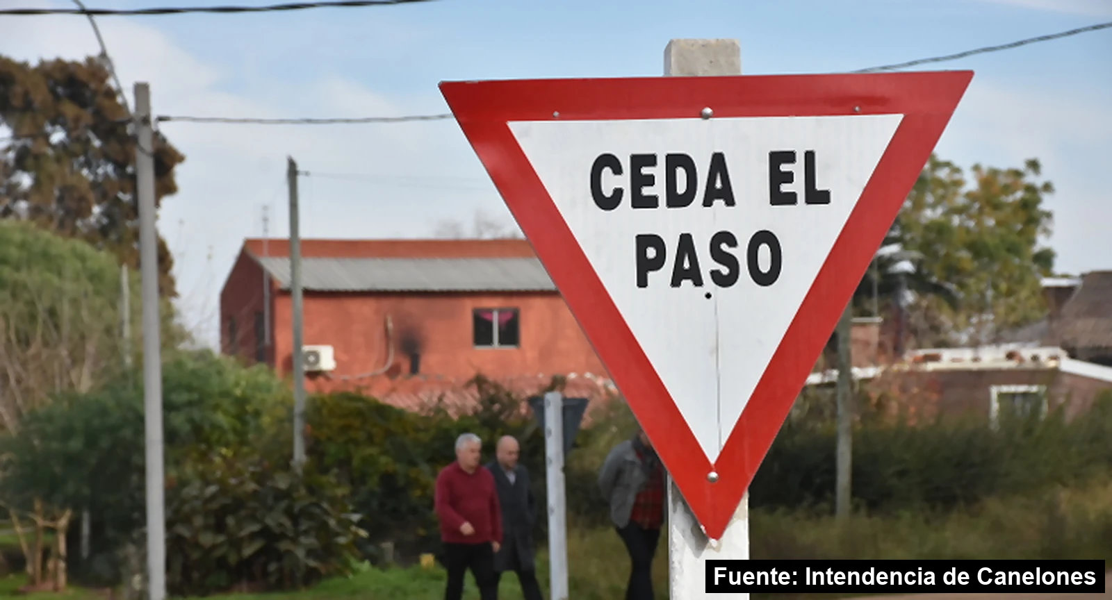 Mayo Amarillo en Colonia Nicolich 6 Cartel nuevo de Ceda el paso en una esquina de Colonia Nicolich, con vecinos caminando al fondo