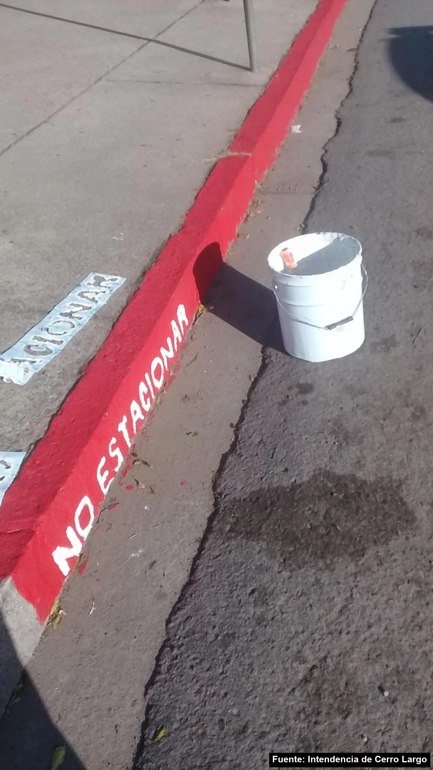 Cordón pintado de rojo con la leyenda no estacionar en una calle de Cerro Largo