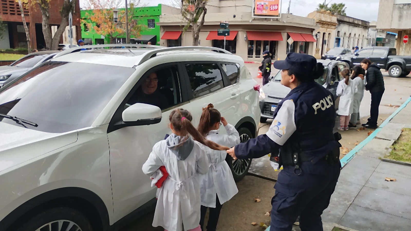 Jornada de Mayo Amarillo en Rocha: escolares de espaldas y Policía Comunitaria conversan con una conductora, 2026.