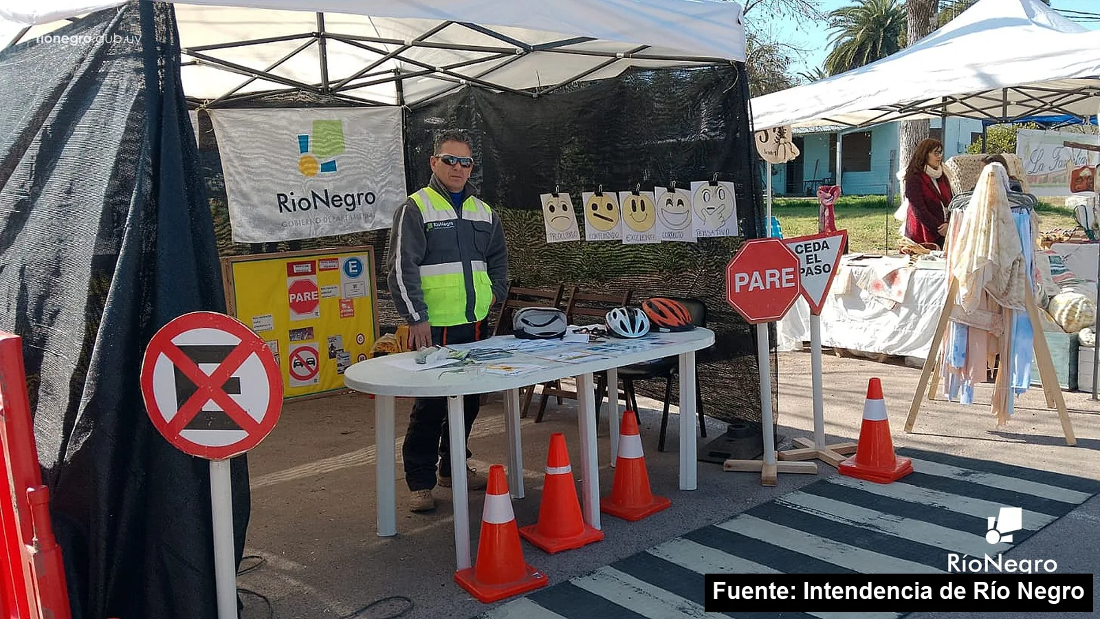 Mayo Amarillo en San Javier 3 Stand de educación vial de la Intendencia de Río Negro con señales de Pare y Ceda el paso, cascos y conos en los festejos de San Javier