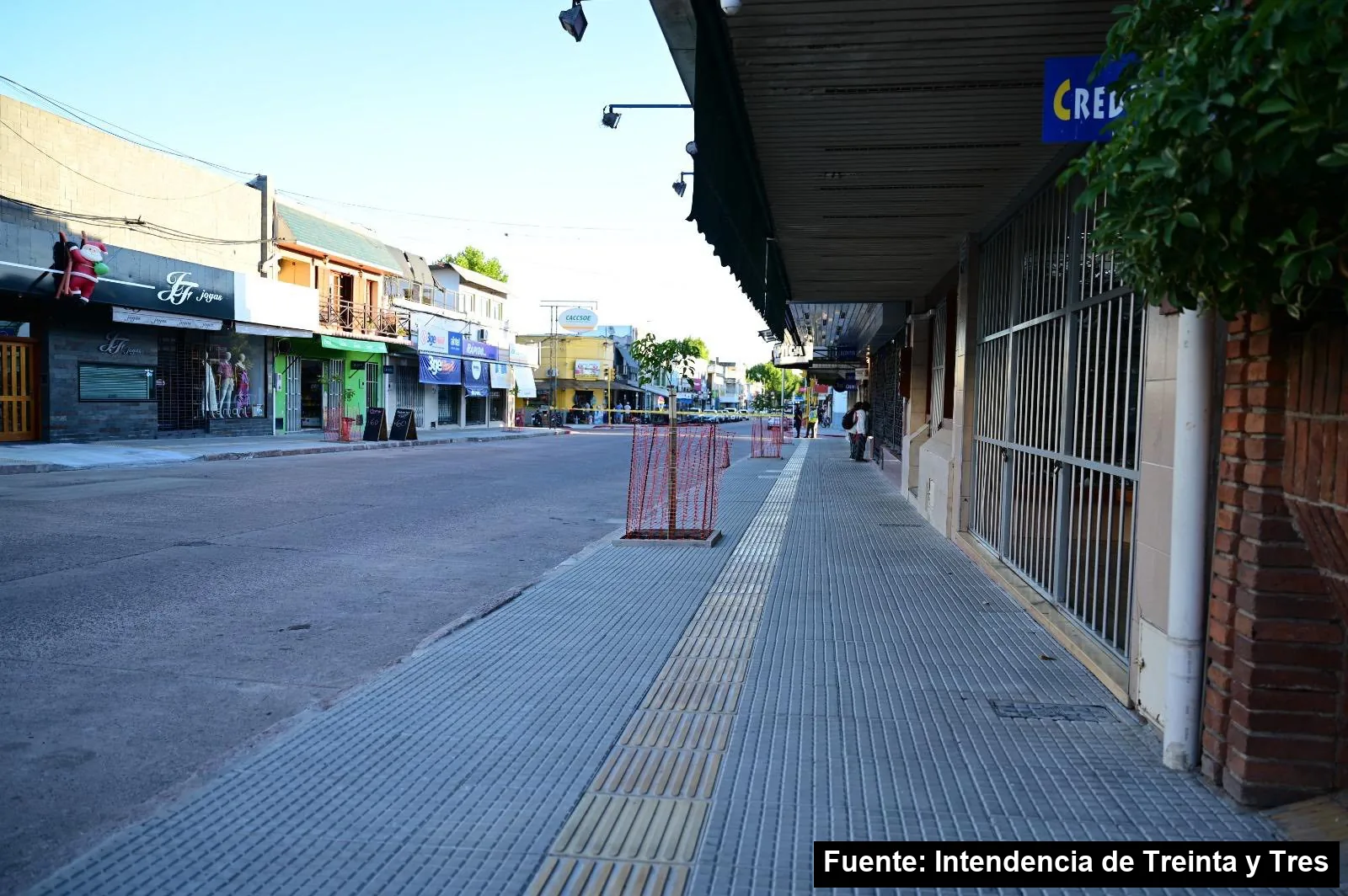 Vereda nueva de la calle Juan Antonio Lavalleja con una senda de baldosas amarillas podotáctiles a lo largo de los comercios